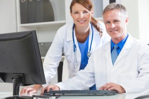 Male & female medical doctors using computer in a hospital office